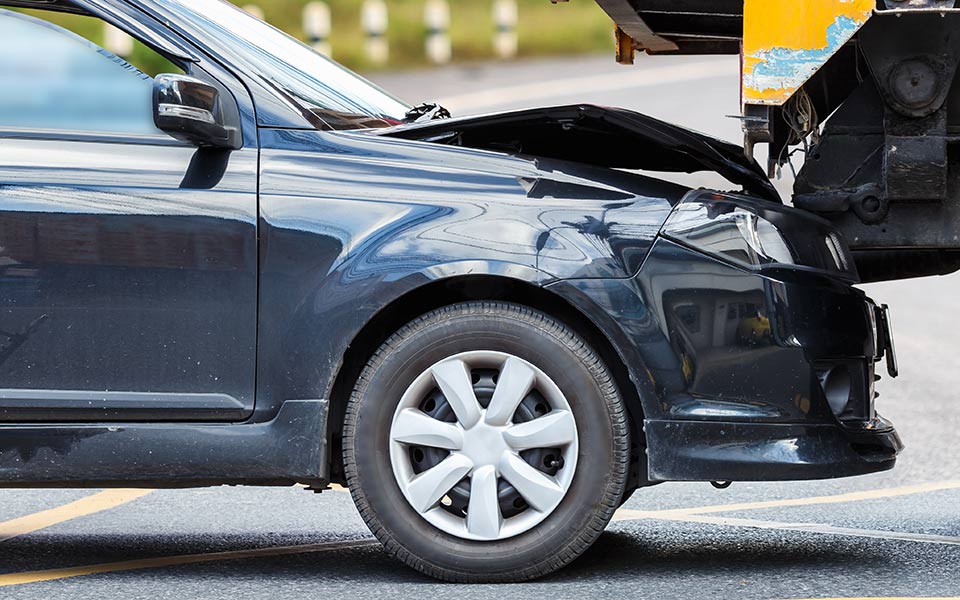 Accident on the road involving black car and yellow truck